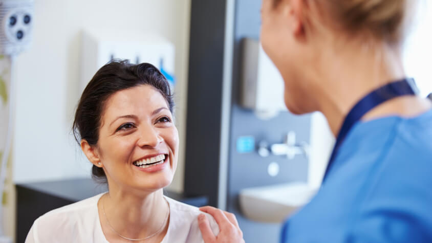 A woman smiling at a health professional