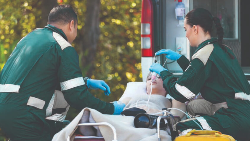 A child getting helped into an ambulance