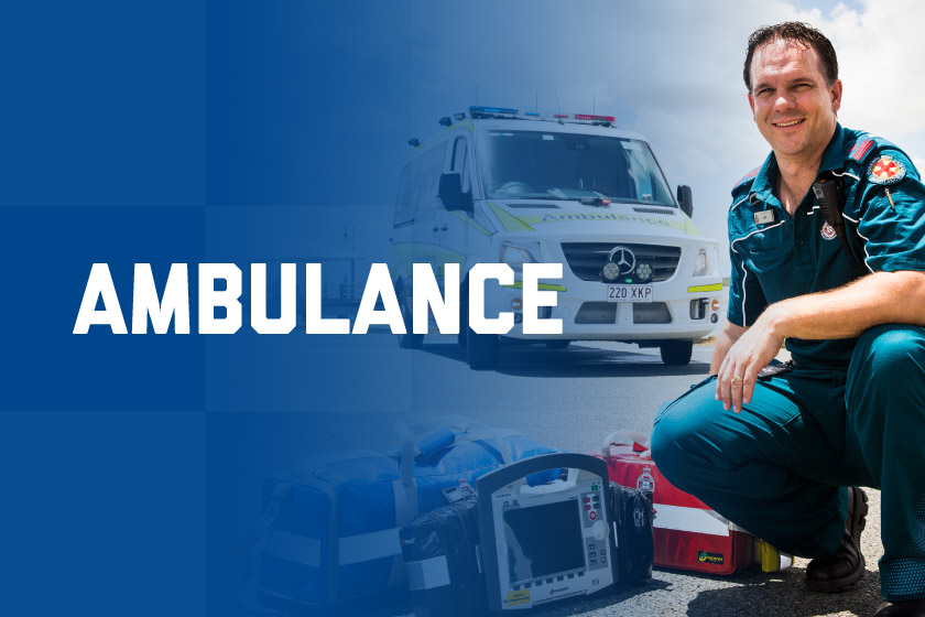 A Paramedic crouching in front of an Ambulance