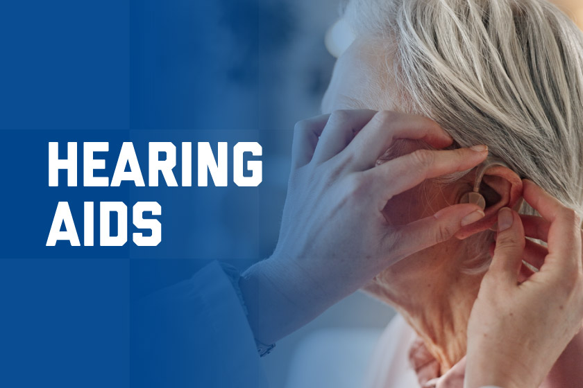 Person inserting hearing aid into elderly woman's ear
